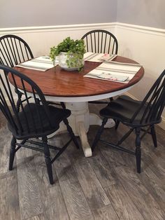 a dining room table with chairs and a potted plant on top of the table