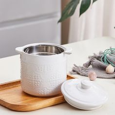 a white pot sitting on top of a wooden tray