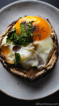 an egg is sitting on top of some sort of bread with leaves and herbs in it