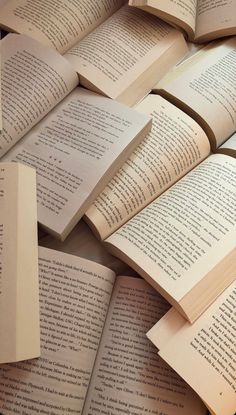 many open books laying on top of each other in the shape of a pile or pyramid