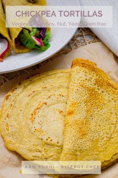 two quesadillas on a plate next to a salad and tortilla