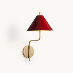 a wall lamp with a red shade on it