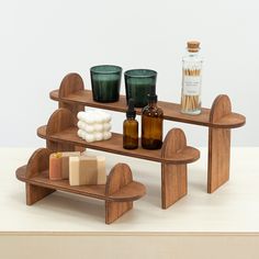 a wooden shelf with soaps, candles and bottles on it