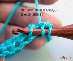 someone is crocheting the end of a piece of yarn with a wooden needle