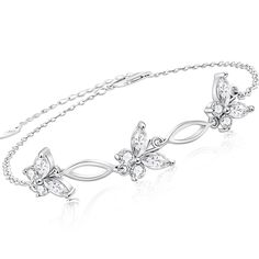 a white gold bracelet with butterflies and leaves on the side, set against a white background