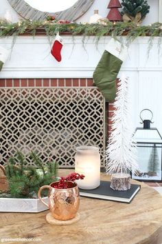 a coffee table with christmas stockings and candles on it in front of a fire place