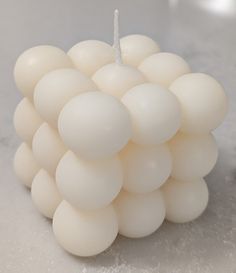 a bunch of white balls sitting on top of a table next to a candle holder