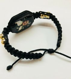 Pulsera hecha a mano de Jesus Malverde doble tejida con hilo reforzado en color negro y bolas chapeado en oro laminado es una pulsera ajustable para hombre o mujer material: hilo reforzado#18 color negro bolas dorado 8mm en oro laminado tableta de madera color negro con imagen de Jesus Malverde por ambos cubierta con resina para no despintarse en cuando suda al usarse Tambien se puede hacer de diferente color de hilo, preguntenos!! porque lo hacermos la pulsera en cuando lo ordena Gold Beaded Friendship Bracelets As Gift, Adjustable Gold Bead Bracelet, Adjustable Gold Bead Bracelet As Gift, Adjustable Gold Beads Bracelet As Gift, Gold Hand-strung Friendship Bracelets As Gift, Gold Hand Wrapped Friendship Bracelets As Gift, Handmade Adjustable Braided Bracelets As Fashion Accessory, Gold Beaded Bangle Jewelry As Gift, Gold Beaded Bangle Jewelry For Gift