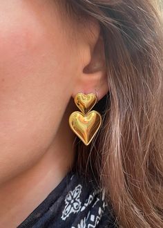 Fall in looooove with the Bryn Heart Earring! This stunning piece features a double heart drop design crafted from precious metal.  1.3" drop 18k gold plated over stainless steel Hypoallergenic Water & tarnish resistant (Though we still don't recommend submerging them or swimming in the ocean with them!) Nickel-free Double Heart Gold Earrings, Nickel-free Gold Double Heart Earrings, Gold Double Heart Nickel-free Earrings, Gold Plated Double Heart Earrings, Trendy Gold Jewelry With Heart Print, Tarnish Resistant Metal Drop Heart Earrings, Tarnish Resistant Metal Heart Drop Earrings, Everyday Metal Double Heart Earrings, Everyday Double Heart Metal Earrings