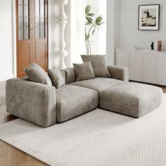 a large sectional couch sitting on top of a rug in a living room next to a doorway