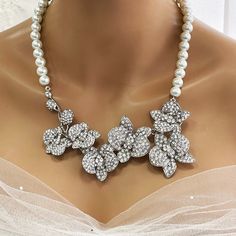 Elevate your bridal look with our Bridal Statement Earrings Necklace Set. Crafted with stunning crystal pearls and intricate orchid flowers, this unique wedding jewelry set adds a touch of elegance to your special day. Designed as the perfect gift for brides, each piece reflects meticulous attention to detail and timeless beauty. Let our set be a cherished part of your unforgettable moments. Embrace authenticity and sparkle with this exquisite ensemble. Dazzle on your special day with our exquis White Flower Bridal Necklace For Wedding, White Floral Bridal Necklace For Wedding, White Crystal Embellished Bridal Earrings For Wedding, Crystal Pearl Necklace With Rhinestones For Wedding, White Rhinestone Bridal Jewelry, Silver Pearl Bridal Accessories For Bride, Silver Pearl Bridal Accessories, Silver Pearl Necklace With Rhinestones For Wedding, White Pearl Bridal Necklace With Rhinestones