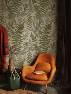 an orange chair sitting in front of a wallpapered with green plants and leaves