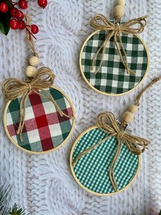 three christmas ornaments hanging from twine on top of a white knitted tablecloth