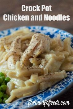 chicken and noodles on a blue and white plate with peas in the foreground text overlay reads crock pot chicken and noodles