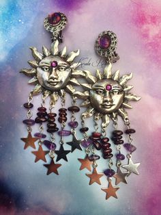 "This pair of Handmade Celestial Earrings is made with antiqued bronze or silver sunshine pendants. Garnet & Amethyst gemstone beads hang from the mystical pair! Celestial star charms dangle from each strand. For an added touch of sparkle a Swarovski rhinestone is on each Sun's third eye. Pierced with french wires (as shown), leverbacks, clip-ons or posts, just select from the pull-down menu. -4 1/2\" Long x 1 3/4\" Wide -0.4. ea. Metal Finishes Available: -Bronze (temporarily sold out) -Sil Sun Chandelier, Wiccan Earrings, Manic Pixie, Celestial Stars, Celestial Earrings, Fantasy Style, Dope Jewelry, Solar Plexus Chakra, Funky Jewelry