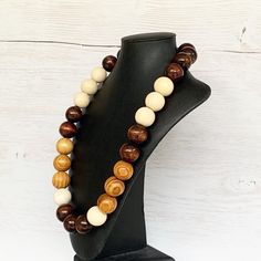 This colorful wood bead necklace was hand beaded using a mix of large 25mm round dark brown, tan, and beige wooden beads in a modern color block design. The necklace measures approximately 28 inches in length and is fastened with a silver clasp. The end result is a cool bohemian piece that fits in perfectly with almost any outfit! Perfect for any gender. Length can be adjusted if needed - just ask! Wood represents a sense of earthiness, spirituality, creativity, liberty, prosperity, health, and Adjustable Brown Round Beaded Necklace, Adjustable Round Brown Beaded Necklace, Adjustable Brown Beaded Round Necklace, Adjustable Brown Beaded Necklace, Handmade Brown Round Beaded Necklaces, Handmade Brown Beaded Necklaces, Brown Wooden Beads Round Jewelry, Brown Wooden Beads Jewelry, Brown Round Wooden Beads Jewelry