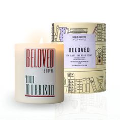 a candle that is sitting next to a box with a label on it and the words beloved