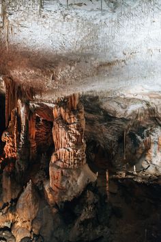 the inside of an underground cave with water and rock formations on it's sides