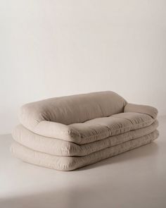 three pillows stacked on top of each other in front of a white wall and floor