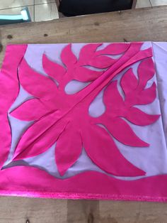 a pink and white piece of cloth on top of a wooden table