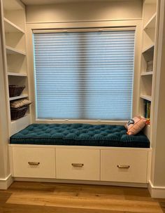 a window seat in the corner of a room with built - in bookshelves