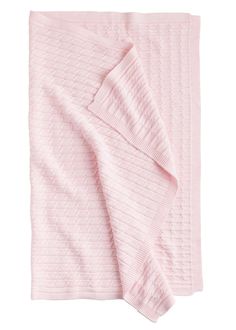 a pink blanket folded on top of a white table