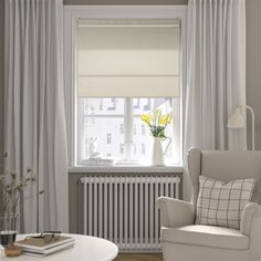 a living room filled with furniture and white curtains