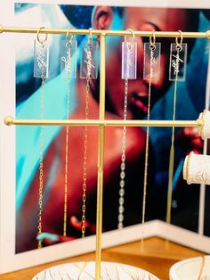 there are many necklaces hanging from the rack on the table next to each other