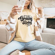 With the "It's All Gravy Baby" Thanksgiving t-shirt in a beautiful mustard color, you can rock your turkey feast with style and humor. Made from soft-as-butter fabric, this tee ensures ultimate comfort as you indulge in the holiday feast. Embrace your love for gravy and show off your witty side with this delightful, must-have addition to your festive wardrobe. Its All Gravy Baby Shirt, Baby Thanksgiving, Funny Baby Shirts, Fall Tshirt, Funny Thanksgiving Shirts, Thanksgiving Tee, Thanksgiving Baby, Holiday Feast, Autumn T Shirts