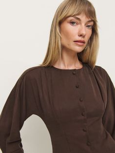 Up top. Shop the Martha Top from Reformation, a 3/4 length sleeve top with a button front, puff sleeves, and a curved hem. Bishop Sleeve Tops With Button Cuffs For Fall, Long Sleeve Blouse With Back Button Closure For Fall, Long Sleeve Tops With Back Button Closure For Fall, Viscose Long Sleeve Office Tops, Workwear Tops With Balloon Sleeves And Button Cuffs, Workwear Tops With Button Cuffs And Balloon Sleeves, Balloon Sleeve Tops With Button Cuffs For Work, Spring Viscose Blouse With Buttons, Fall Office Puff Sleeve Long Top