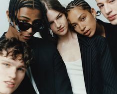 four young men and one woman posing for the camera