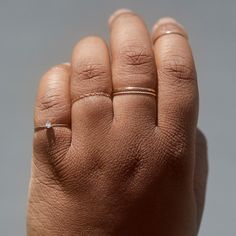 a person's hand with two rings on it and one ring in the middle