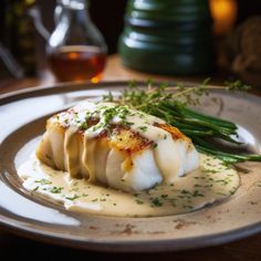 a white plate topped with scallops covered in gravy and green beans