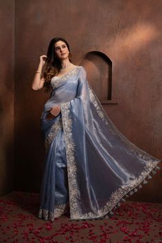 Indulge in the pure luxury of our Hand Embroidered Blue Tissue Organza Saree. Each thread is carefully and meticulously embroidered by hand, creating a one-of-a-kind piece that exudes elegance and sophistication. Elevate your style and make a statement with this exclusive saree. SKU: 0005 Luxury Tissue Silk Saree With Motifs, Luxury Chinon Saree With Chikankari Embroidery, Elegant Tissue Silk Blouse With Floral Embroidery, Blue Tissue Silk Saree For Reception, Luxury Embroidered Festive Traditional Wear, Blue Tissue Silk Traditional Wear For Party, Blue Traditional Wear With Sheer Dupatta In Tissue Silk, Blue Blouse Piece In Tissue Silk With Traditional Drape, Blue Embroidered Tissue Silk Blouse Piece