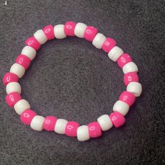 Material: Clear string Color: Pink and blue beads Type: Bracelet Style: Casual Pink Stretch Bracelet With Round Beads For Friendship, Pink Hand-strung Bangle Stretch Bracelet, Trendy Pink Stretch Bracelet With Large Beads, Pink Trendy Hand-strung Stretch Bracelet, Trendy Pink Hand-strung Stretch Bracelet, Adjustable Pink Stretch Bracelet, Trendy White Bracelet With Large Beads, Pink Stretch Bracelet With Colorful Beads For Friendship, Pink Hand-strung Beaded Bracelets For Beach