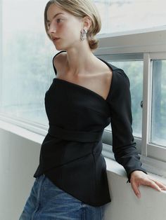 This product is a Square Neck Tulip Blouse that combines a structured square neckline with the soft, flowing lines of a tulip-shaped body, offering a blend of geometric and organic design elements. The blouse features a fitted waist that accentuates the silhouette, while the peplum detail adds a touch of drama and femininity to the overall aesthetic. Crafted to provide a sophisticated and polished look, this piece is perfect for both formal and casual settings. - The blouse boasts a square neckline that frames the collarbones and lends a modern edge.- A peplum waist creates a flattering tulip-like silhouette that enhances the garment's elegance.- The long sleeves add a traditional touch, balancing the contemporary neckline and fitted bodice.- Constructed with a blend of materials that Chic Square Neck Stretch Top, Modern Stretch Tops With Square Neck, Elegant Evening Blouse With Structured Shoulders, Party Tops With Structured Shoulders And Long Sleeves, Long Sleeve Tops With Structured Shoulders For Party, Formal Off-shoulder Tops For Fall, Chic Stretch Square Neck Top, Evening Tops With Structured Shoulders And Long Sleeves, Fitted Party Blouse With Structured Shoulders