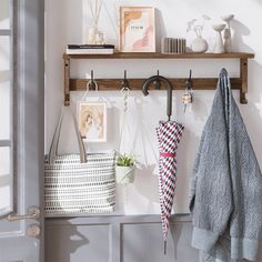 a coat rack with two umbrellas hanging from it's hooks and some pictures on the wall