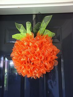 an orange wreath hanging on the front door