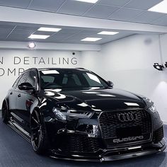 a black car is parked in a showroom