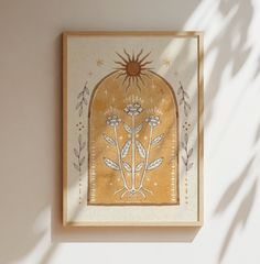 a painting is hanging on the wall in front of a white wall with a sun above it