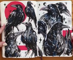 two black crows sitting on top of each other in front of markers and pencils