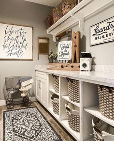 a laundry room with white cabinets and baskets on the shelves next to a black and white rug