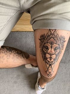 a man's legs with tattoos on them, and his leg is shown in the shape of a lion