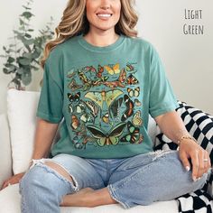 Vintage Butterfly and Moth T Shirt, Comfort Colors, Cottagecore Aesthetic Shirt, Art Shirt, Gift For Her, Nature Lover Tee, Boho Clothing, Botanical Outfit, Cute Shirt For Teen, Gift For Mom, Gardening Shirt, Garden Tee, Science Shirt, Entomology Shirt, Gift for Entomologist, Science Teacher Shirt, Educational TShirt, Vintage Art Shirt, Boho Design, Moth Shirt, Fairycore TShirt 🦋 Step into a world of enchantment and elegance with our Vintage Butterfly & Moth Identification tshirt for women, a masterpiece that seamlessly marries the captivating allure of 26 distinct butterfly and moth species with the timeless comfort of the Comfort Colors brand. Embrace the whimsical charm as you indulge in the delicate beauty of these winged wonders, all elegantly labeled with their respective names. ©️A Casual Green Top With Butterfly Print, Vintage Cotton Tops With Butterfly Print, Butterfly Print Relaxed Fit Crew Neck Top, Butterfly Print Crew Neck Top With Relaxed Fit, Relaxed Fit Butterfly Print Crew Neck Top, Relaxed Cotton Top With Butterfly Print, Fairycore Tshirt, Botanical Outfit, Moth Shirt