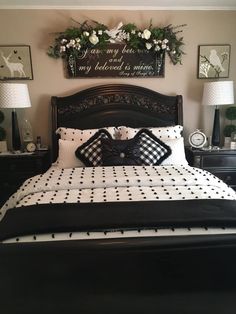 a black and white bed in a bedroom with two lamps on either side of the bed