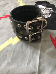 Four row studded punk bracelet on black leather and has two buckles Edgy Black Cuff Bracelet With Rivets, Edgy Black Cuff Bracelet For Concerts, Black Edgy Wristband With Studs, Black Gothic Leather Bracelet With Studs, Gothic Black Studded Leather Bracelet, Black Riveted Bracelets For Concerts, Black Leather Bracelet With Studs For Rock Style, Black Leather Bracelet With Studs, Black Leather Bracelets With Studs