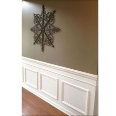 a snowflake is mounted on the wall above a wood floor