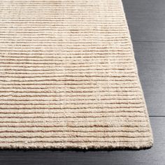 a beige rug on top of a wooden floor