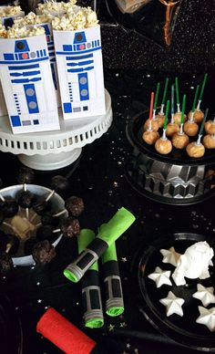 star wars themed desserts and snacks on a black table with silver utensils