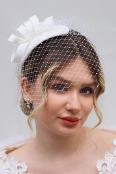 This is a handcrafted cocktail wedding fascinator hat with a leaf shape design, hair comb, and face netting veil. The color is off-white, which goes with common wedding dress colors. It is made in a standard one-size, and it has a hair comb under it, so it can be worn easily without the support of a hairdresser. The hat is made of matte satin fabric with lace in the middle. Other models are available in various colors; check them out here: https://www.etsy.com/shop/ArtisanTulipBridal?section_id= Wedding Costume Hats And Headpieces With Handmade Flowers, Elegant Wedding Hats And Headpieces With Handmade Flowers, Elegant White Hats For Vintage Events, White Gatsby Wedding Hat, Elegant White Hat For Vintage Events, Elegant Handmade Flowers Headband, Elegant Cream Party Veil, Adjustable Fascinator For Wedding, Gatsby Style Wedding Headband Hat